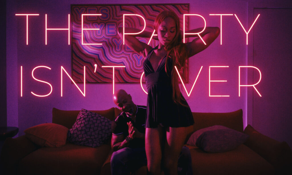 Title card for "The Party Isn't Over." Vanniall stands in front of a couch, Soldier Boi behind her, both lit in pink and purple.